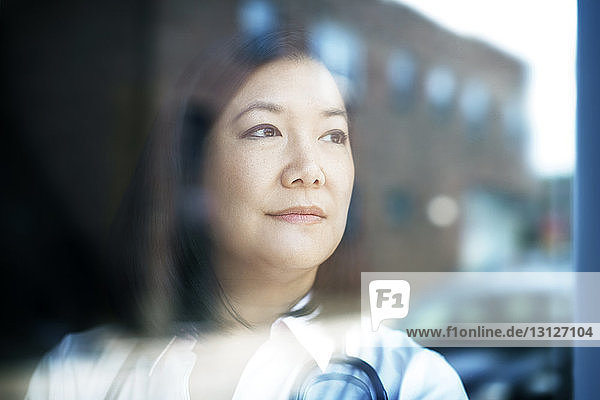 Close-up of thoughtful female doctor seen through window