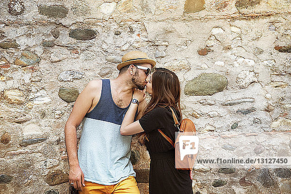 Couple kissing against wall