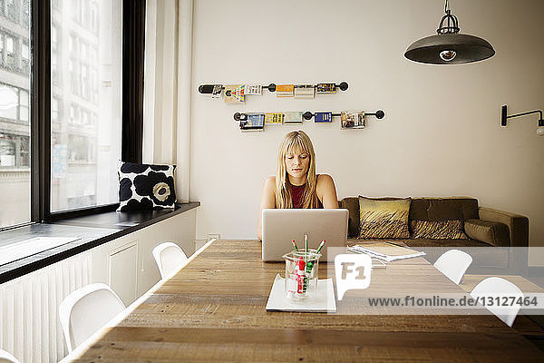 Geschäftsfrau benutzt Laptop im Kreativbüro