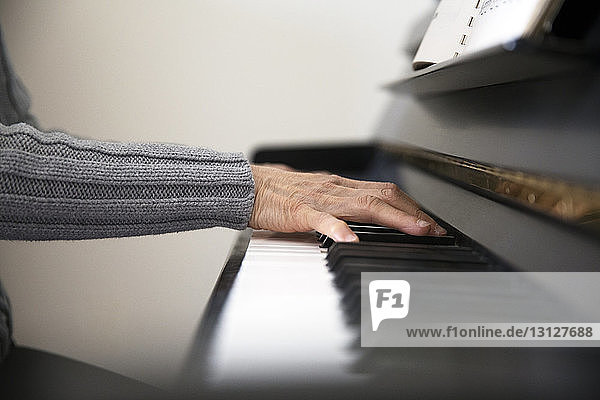 Ausgeschnittenes Bild einer älteren Frau  die zu Hause Klavier spielt