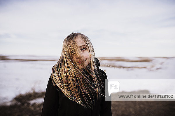 Porträt eines Mädchens  das im Winter auf dem Feld steht