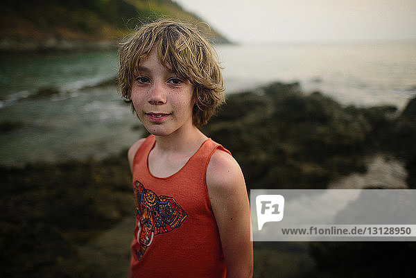 Portrait of boy standing against sea