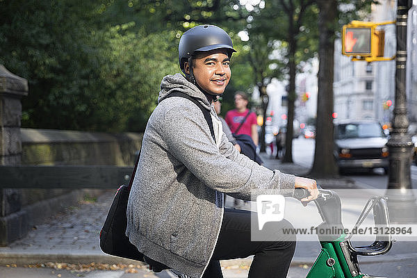 Porträt eines glücklichen Mannes auf dem Fahrrad in der Stadt