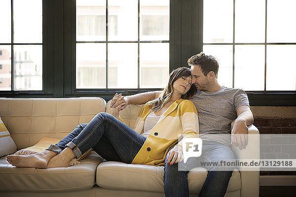 Couple relaxing on sofa at home