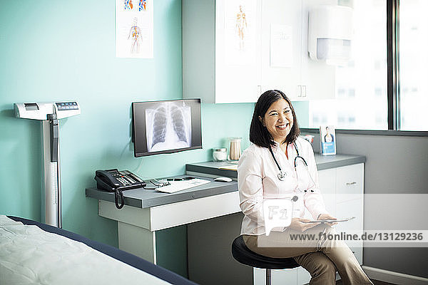 Porträt einer glücklichen Ärztin  die in der Klinik sitzt