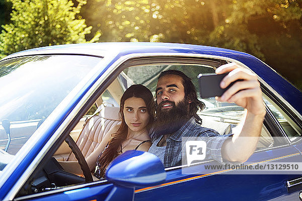 Couple taking selfie while sitting in pick-up truck