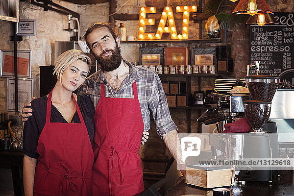 Portrait of owners standing in cafe