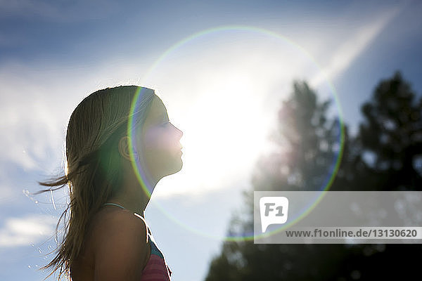 Seitenansicht eines Mädchens gegen den Himmel an einem sonnigen Tag
