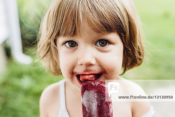 Nahaufnahme-Porträt eines Mädchens  das Eis am Stiel isst