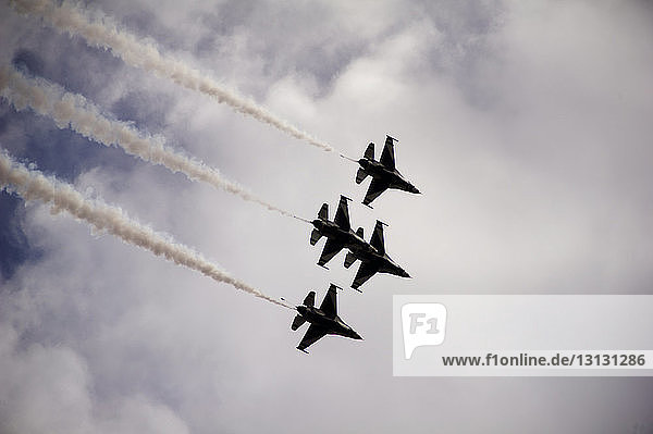 Tiefwinkelansicht von Militärflugzeugen während einer Flugschau bei bewölktem Himmel