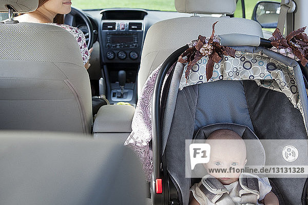 Hochwinkelporträt eines im Autositz sitzenden Kleinkindes