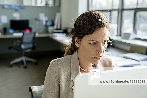 Geschäftsfrau benutzt Desktop-Computer  während sie im Büro sitzt