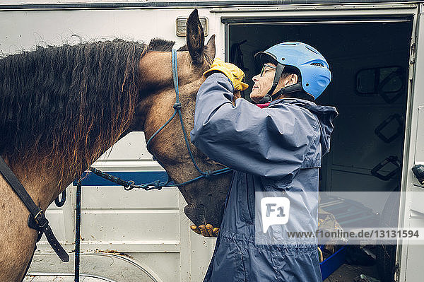 Ärztin untersucht Pferd  während sie im Krankenwagen steht