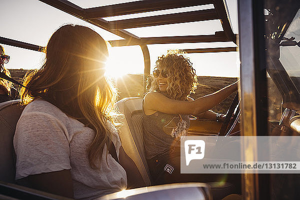 Freundinnen  die an sonnigen Tagen im Geländewagen sitzen