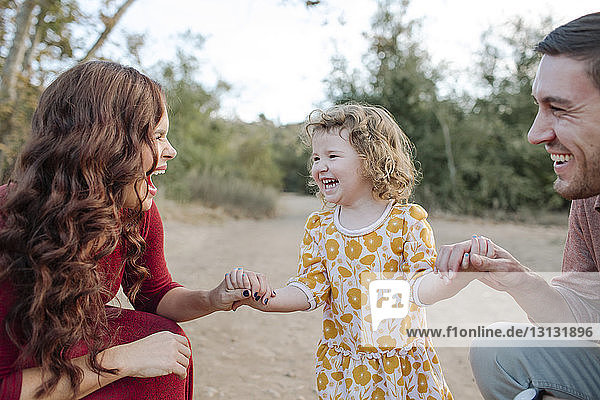 Man looking at cheerful mother with daughter
