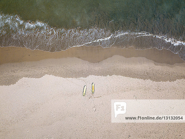 Hochwinkelansicht von Surfbrettern am Strand während eines sonnigen Tages