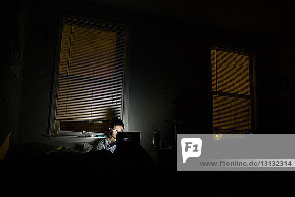 Frau benutzt Laptop-Computer in der Dunkelkammer zu Hause