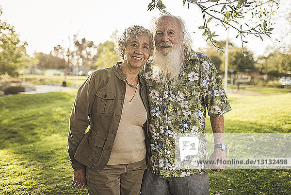 Portrait of confident senior couple standing at park