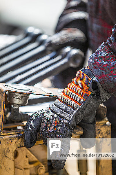 Cropped image of worker using machinery at industry