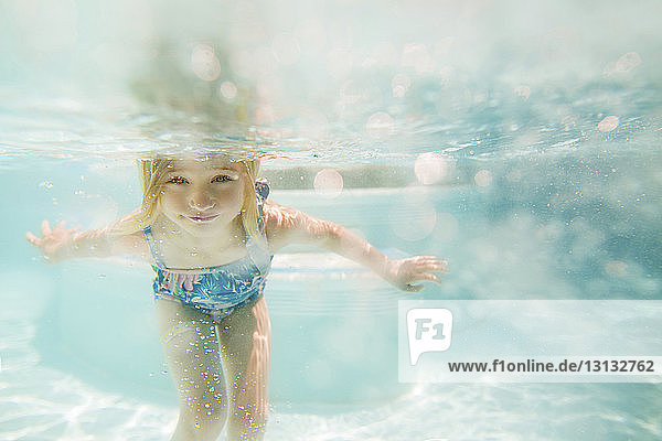 Girl swimming in pool on sunny day