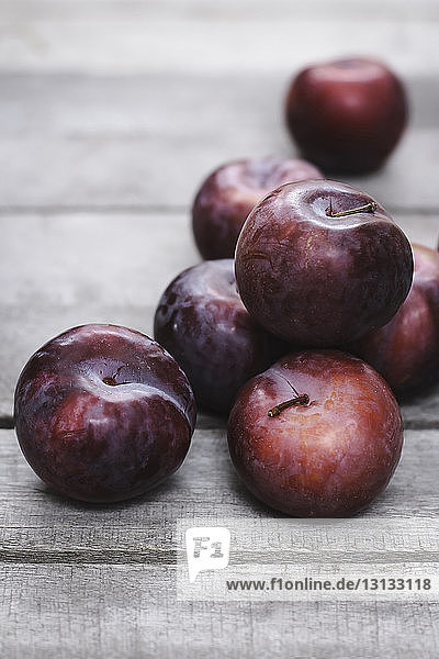 High angle view of plums on wooden table