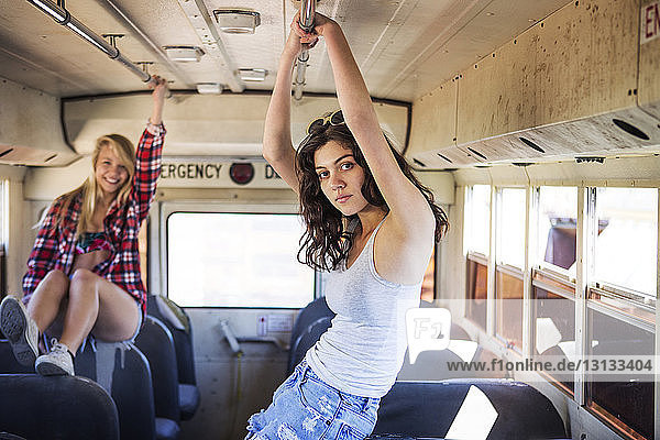 Portrait of woman with happy friend in old bus