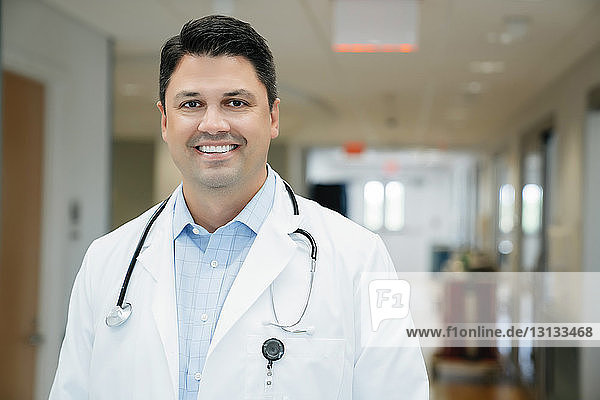 Portrait of confident doctor standing in hospital corridor