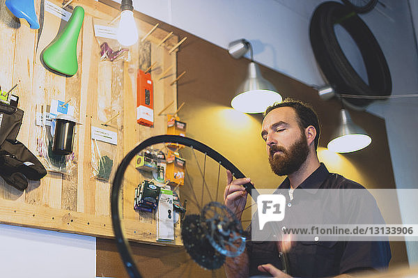 Mechaniker betrachtet Fahrradreifen in der Werkstatt