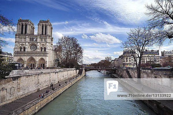 Notre Dame de Paris am Fluss gegen bewölkten Himmel