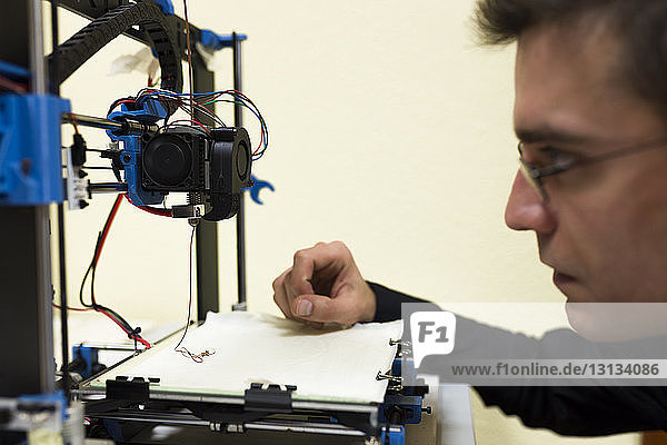 Zuversichtlicher Ingenieur untersucht 3D-Drucker auf dem Tisch