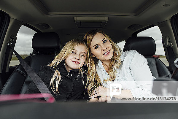 Portrait of mother and daughter sitting in car
