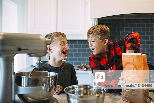 Glückliche Brüder  die zu Hause in der Küche das Essen zubereiten