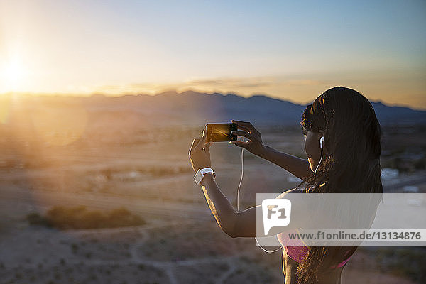Sportlerin fotografiert bei Sonnenschein per Handy