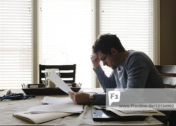 Businessman with head in hand working in office