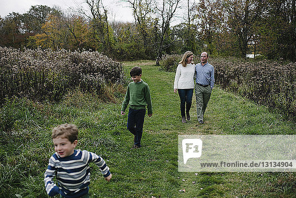 High angle view of family walking on grassy field at park