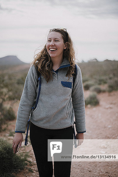 Cheerful female hiker walking on field at Red Rock Canyon National Conservation Area