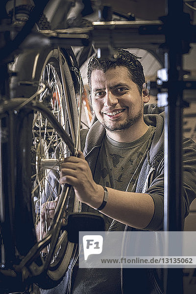 Porträt eines Kunden  der Fahrradreifen im Geschäft untersucht