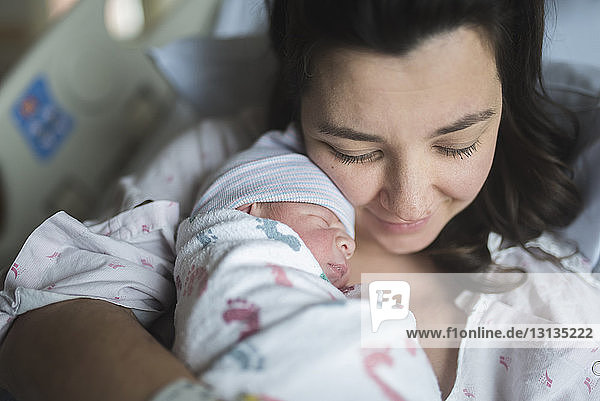 Hochwinkelaufnahme einer Mutter mit einem neugeborenen Sohn  der sich im Krankenhaus auf dem Bett ausruht
