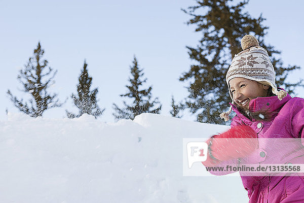 Cheerful girl running on snowy field
