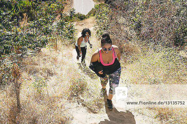 High angle view of female friends walking on mountain while exercising
