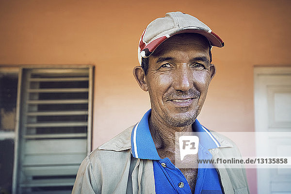 Portrait of smiling man standing by house