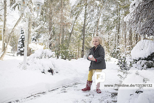 Girl playing with snow at park