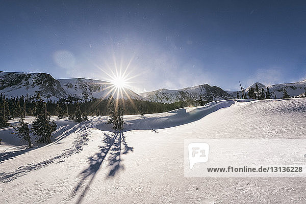 Szenische Ansicht einer schneebedeckten Landschaft gegen den Himmel bei sonnigem Wetter