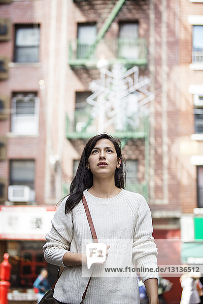Thoughtful young woman walking in city