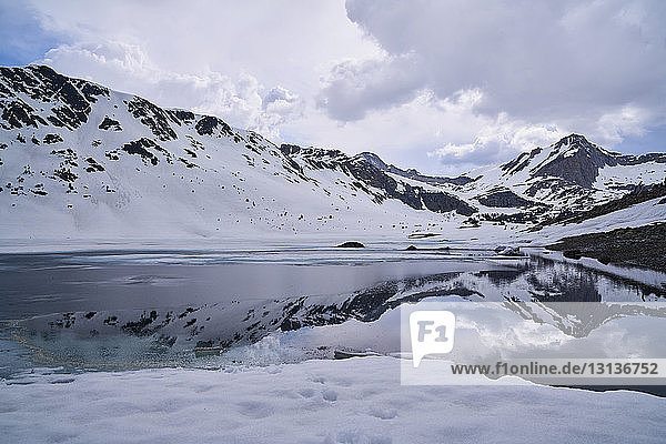 Landschaftliche Ansicht von schneebedeckten Bergen  die sich auf einem ruhigen See spiegeln