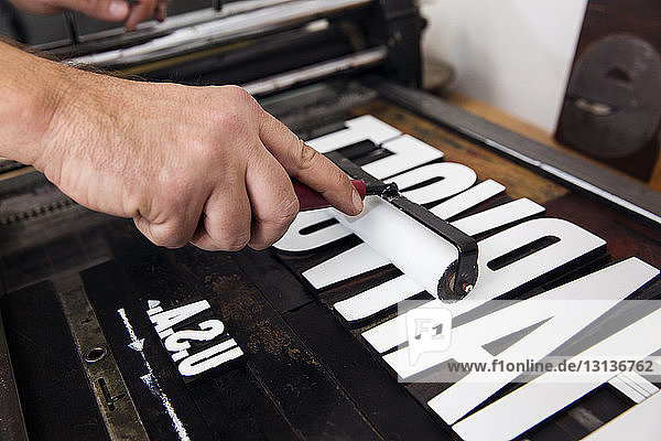 Beschnittenes Bild von handgemalten hölzernen Alphabeten in einer Druckerpresse