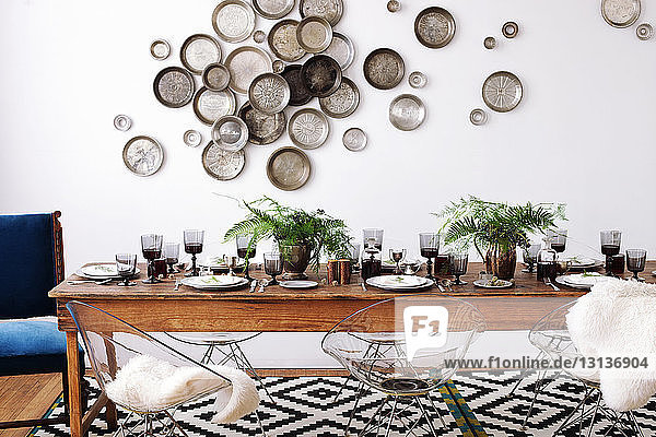 Arranged dining table against decorated wall