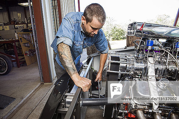 Mechanic repairing engine in auto repair shop