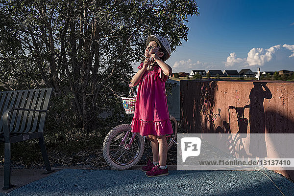 Mädchen nimmt Fahrradhelm ab  während sie im Park steht