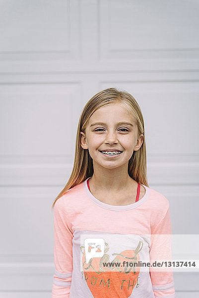 Porträt eines lächelnden Mädchens  das vor der Tür steht